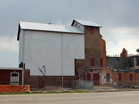 The Windsor Milling and Elevator Company building at 301 Main Street in August 2012, its white elevator and brick mill under reconstruction